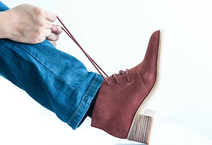 close-up-of-a-brown-leather-boot-being-tied-720x495