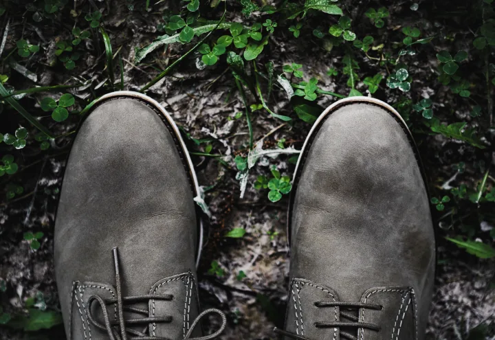 close-up-of-two-shoes-stepping-on-grass-720x495